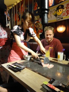 The waitress cooking us typical Japanese meals directly on our table.  Notre serveuse nous cuisinant des mets typiques du Japon directement à notre table
