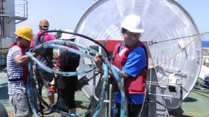 Sudipta and Yi-Wei bringing the streamer close to the boxes to wind them and put them back in.  Sudipta et Yi-Wei s'apprêtant à enrouler la flûte sismique sur elle-même afin de la ranger dans sa boîte.