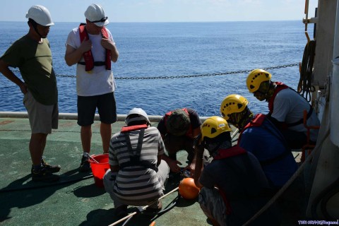 Gero attaching two buoys close to the cable/streamer connexion. <em> Gero attachant deux flotteurs au niveau du connecteur câble/flûte. Photo: Raymond Shih