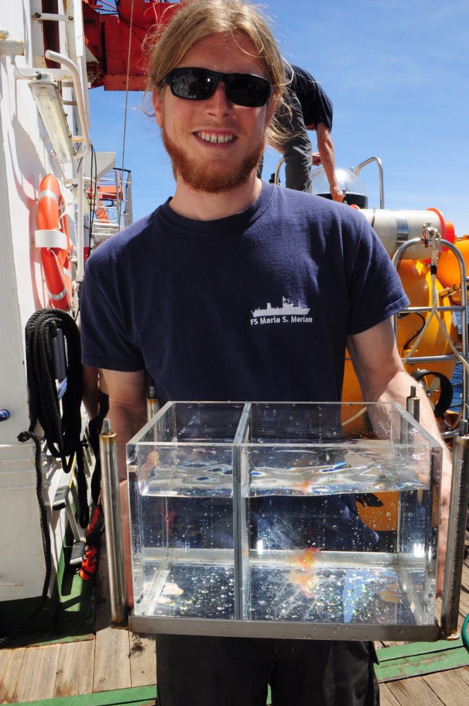 Tauchbootpilot Peter Striewski zeigt den Sammelbehälter der Saugpumpe von JAGO in dem eine grosse Staatsqualle (Siphonophore) schwimmt / JAGO pilot Peter Striewski shows the collecting tank of the pump of JAGO in which a big Staatsqualle (Siphonophore) floats. Photo: Karen Hissmann /JAGO - Team