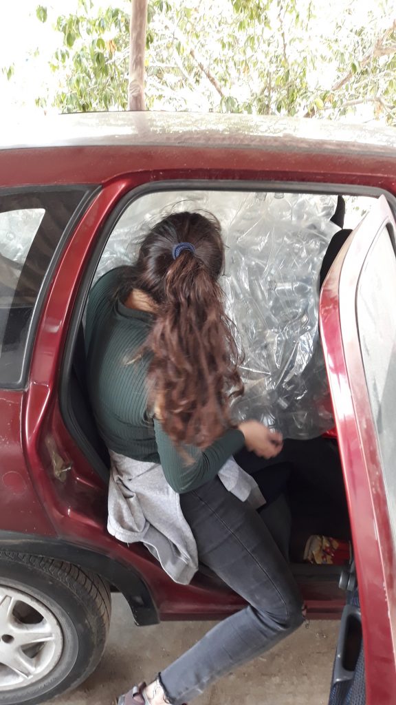 Abril struggling to fit into the car that was already filled with 200 PET bottles (Photo: Jonas Barkhau)