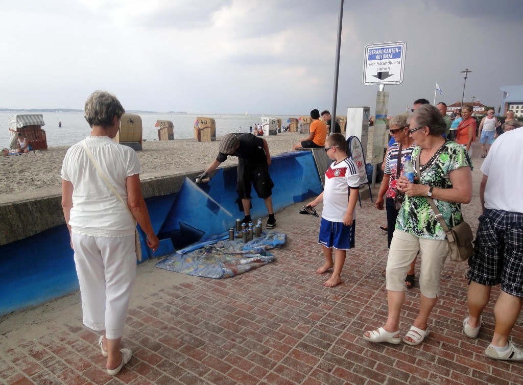 Das meterlange  besprühen der Flutmauer mit visualisiertem Meeresspiegelanstieg gehört zu den Publikumsmagneten an diesem Wochenende (Foto: C.Koch)