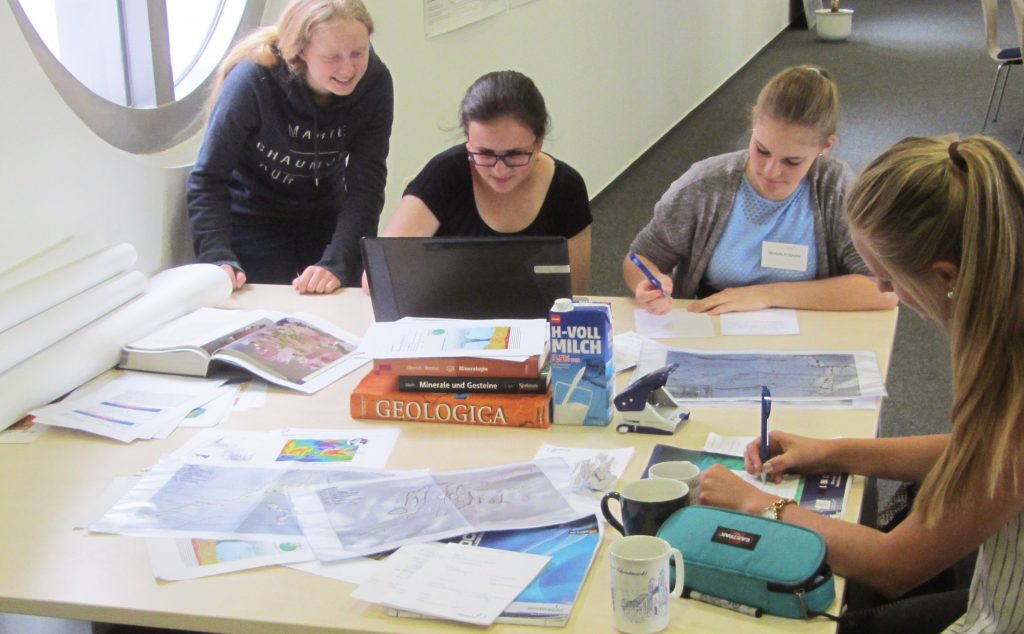 Books, papers, maps, and coffee – like actual scientists, the girls work together on their final presentation. / Bücher, Artikel, Karten und Kaffee – wie echte Wissenschaftler arbeiten die Mädels gemeinsam an ihrem Abschlussvortrag. (© M. Klischies)