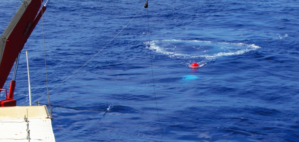 Airguns are towed behind the ship and release air (white bubbles underneath the red buoy) every 12 seconds. The circle of white foam is due to the previous „shot“ of air that reached the sea surface. / Die Luftkanonen werden hinter dem Schiff geschleppt und entlassen alle 12 Sekunden gepresste Luft (weiße Blase unterhalb der roten Boje). Der Ring aus weißem Schaum entsteht beim Aufsteigen der Luftblase an die Meeresoberfläche. (© M. Klischies)