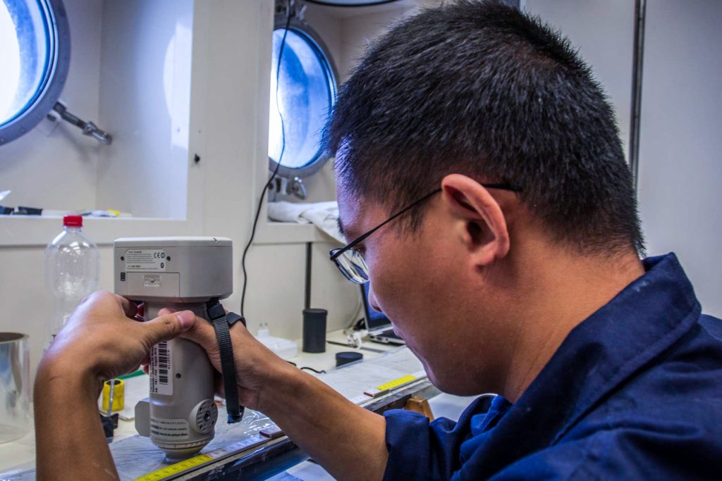 Jianxing Liu (FIO) analyzing a carbonate-rich core from 1771 m water depth for it’s specific color-spectrum. Photo: Thomas Ronge, editing: Steffen Niemann