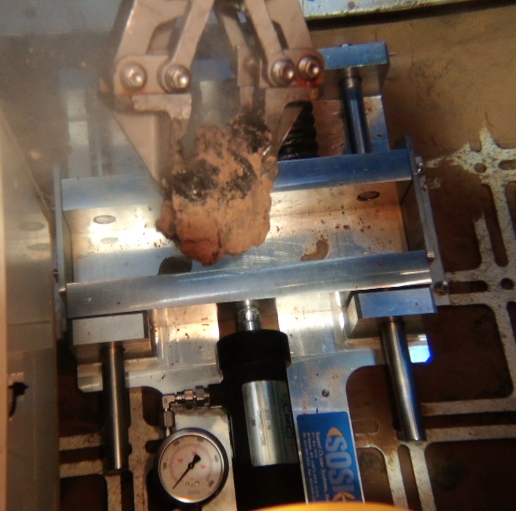 At 4300 m depth the manipulator of ROV KIEL 6000 places a Mn nodule into the crusher. Photo: ROV KIEL 6000, GEOMAR