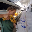 Lena drilling holes for the water pipes.