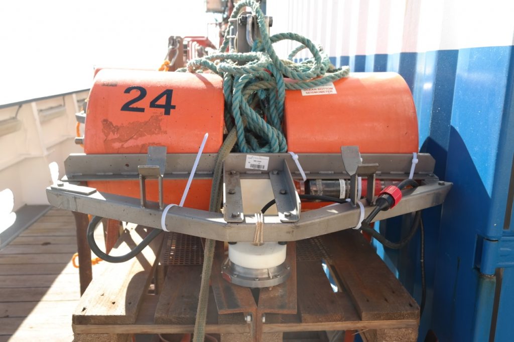 An OBS on the working deck of RV Merian. The orange cylinders are the floatations which make sure that the instrument will come back to the surface. Photo: Martha Deen