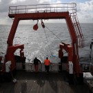 Fast fünf Minuten lang wurde die Dredge (blaues Netz) über den Meeresboden hinter dem Schiff hergezogen. Hier sieht man, wie sie an Deck geholt wird. Foto: G. Seidel, GEOMAR