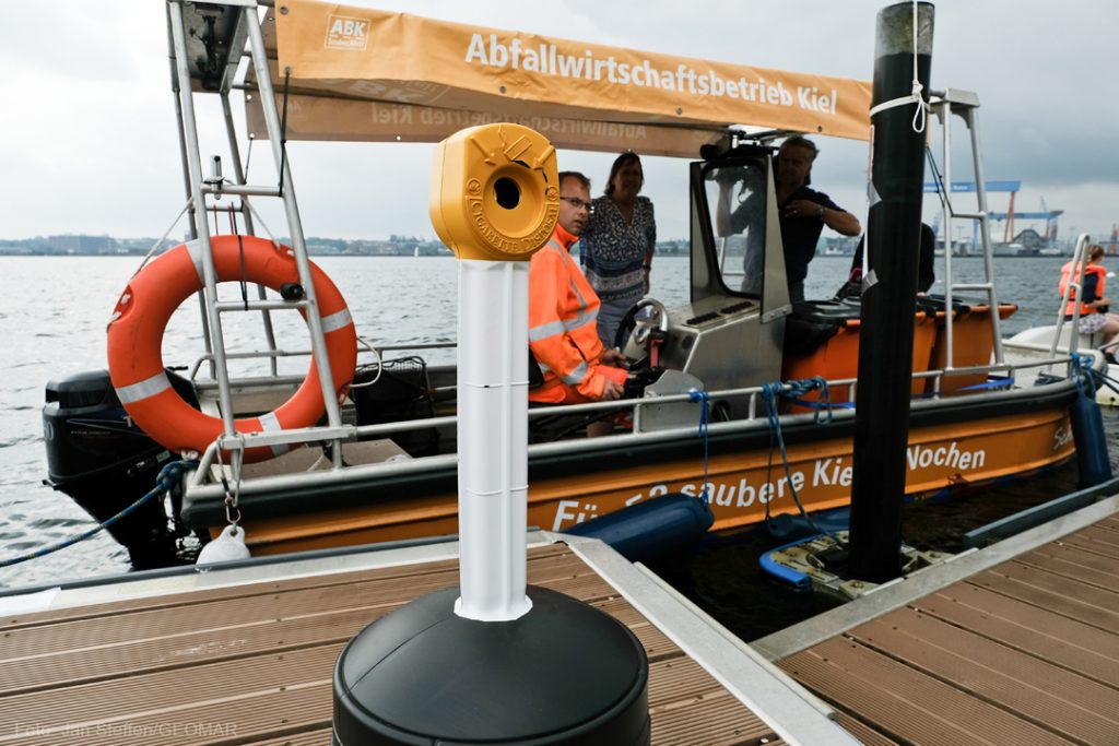 Hier seht ihr einen der Standaschenbecher, die ihr während der Kieler Woche überall finden könnt. Im Hintergrund legt gerade die Schiermoker zum Müllsammeln in der Förde ab. Photo: Jan Steffen / GEOMAR